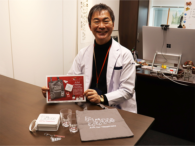 チャリティーグッズを持つ宮崎さん